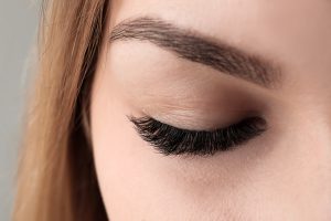 Close-up of a closed eye with defined brow and dark lashes