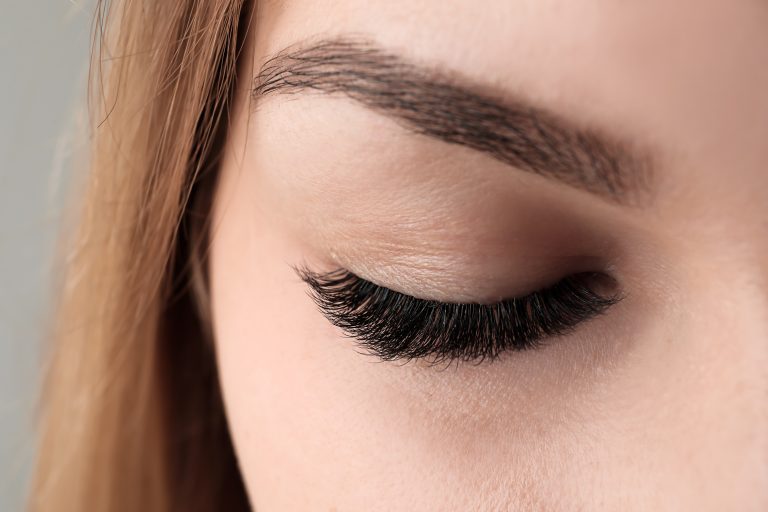 Close-up of a closed eye with defined brow and dark lashes